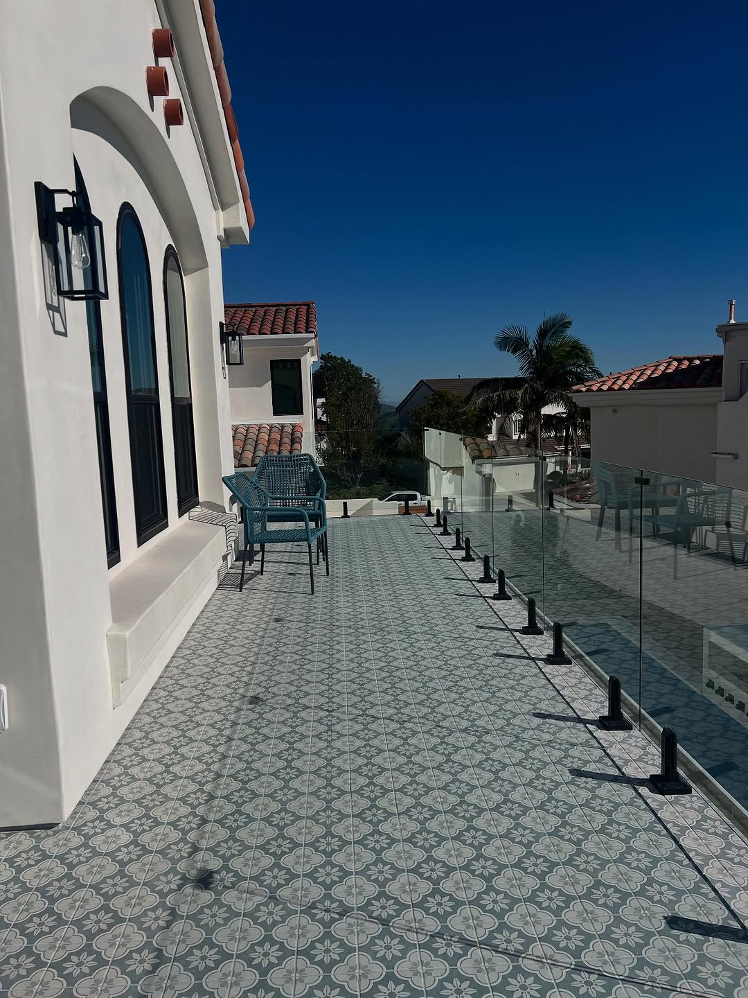 Patterned tile patio with a glass rail and ocean view