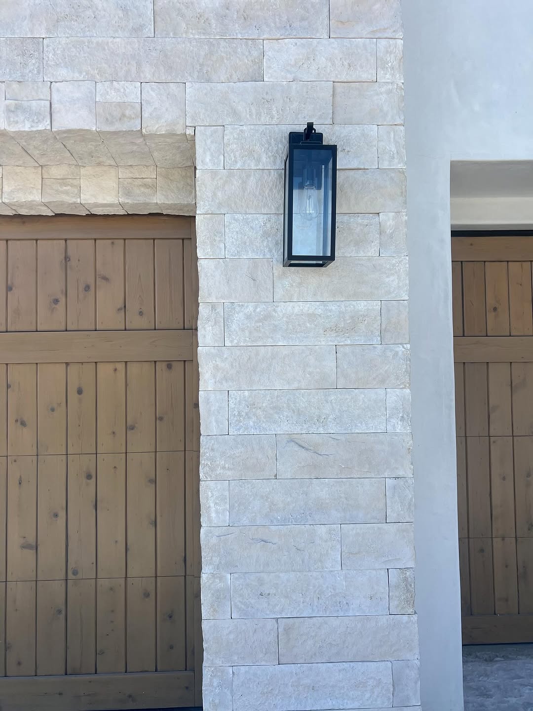 Stone clad column beside a wood gate